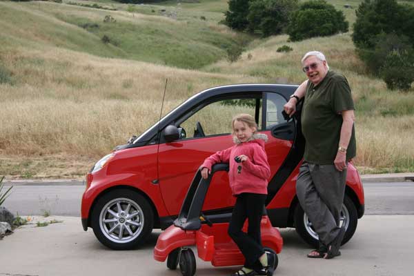 Papa and Nyah beside their cars.